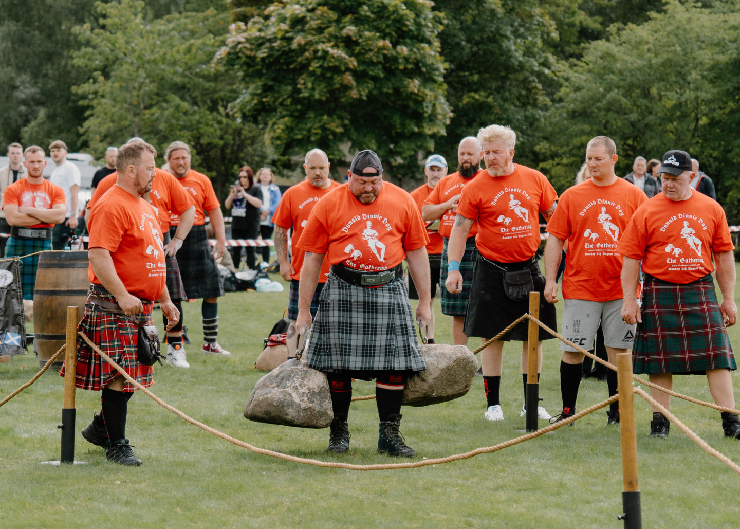 A competitor lifting two large stones at a Scottish gathering