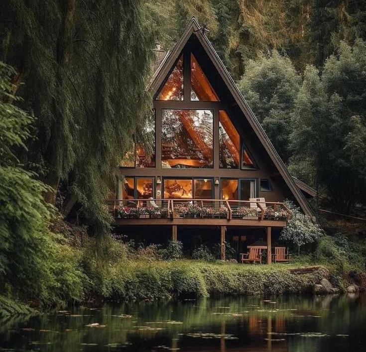 A timber home set among trees beside still water